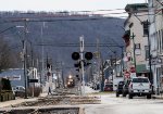 Telephoto view looking down third Street in Sunbury as a northbound freight train approaches